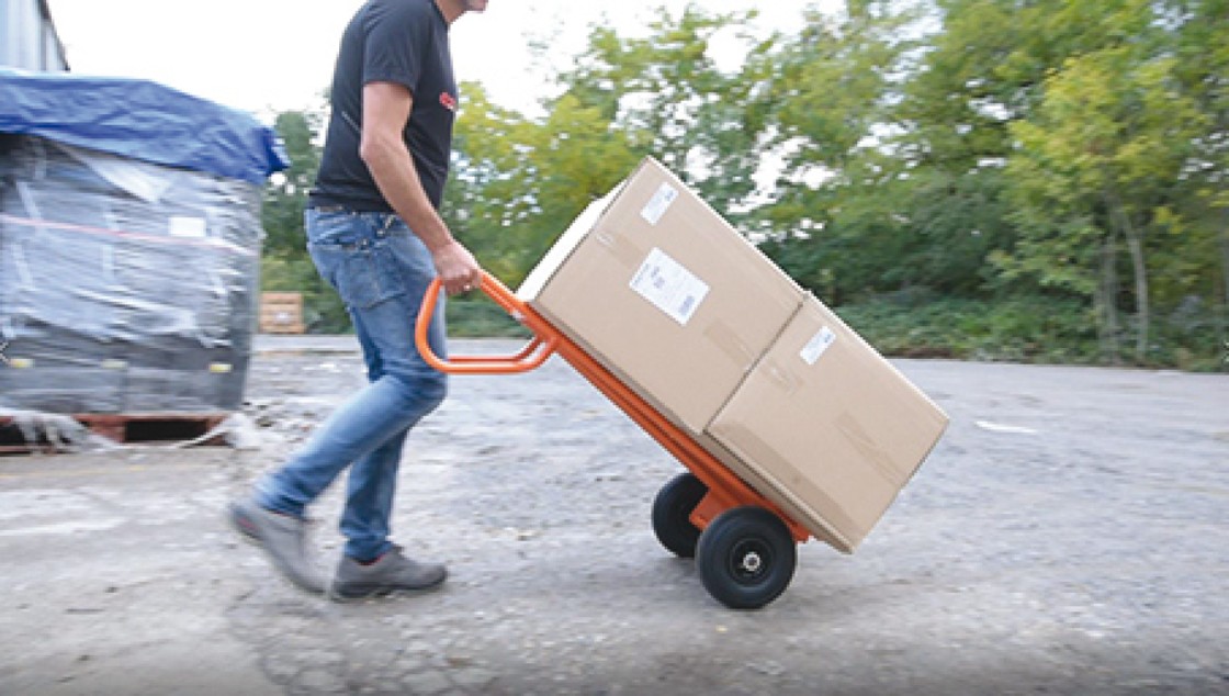 Livreur transportant des colis avec Axis, le diable professionnel ultra-robuste de Mondelin