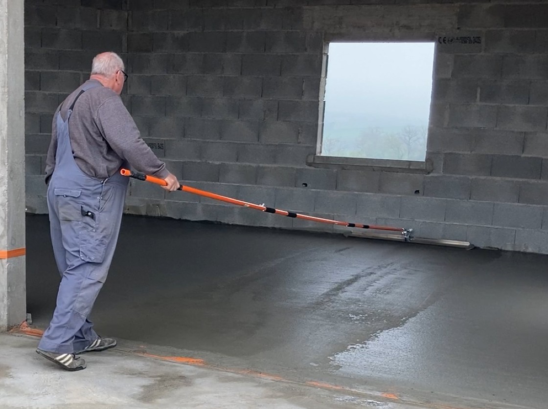 Artisan dallagiste utilisant la lisseuse de dalle béton professionnelle sur perche par Mondelin