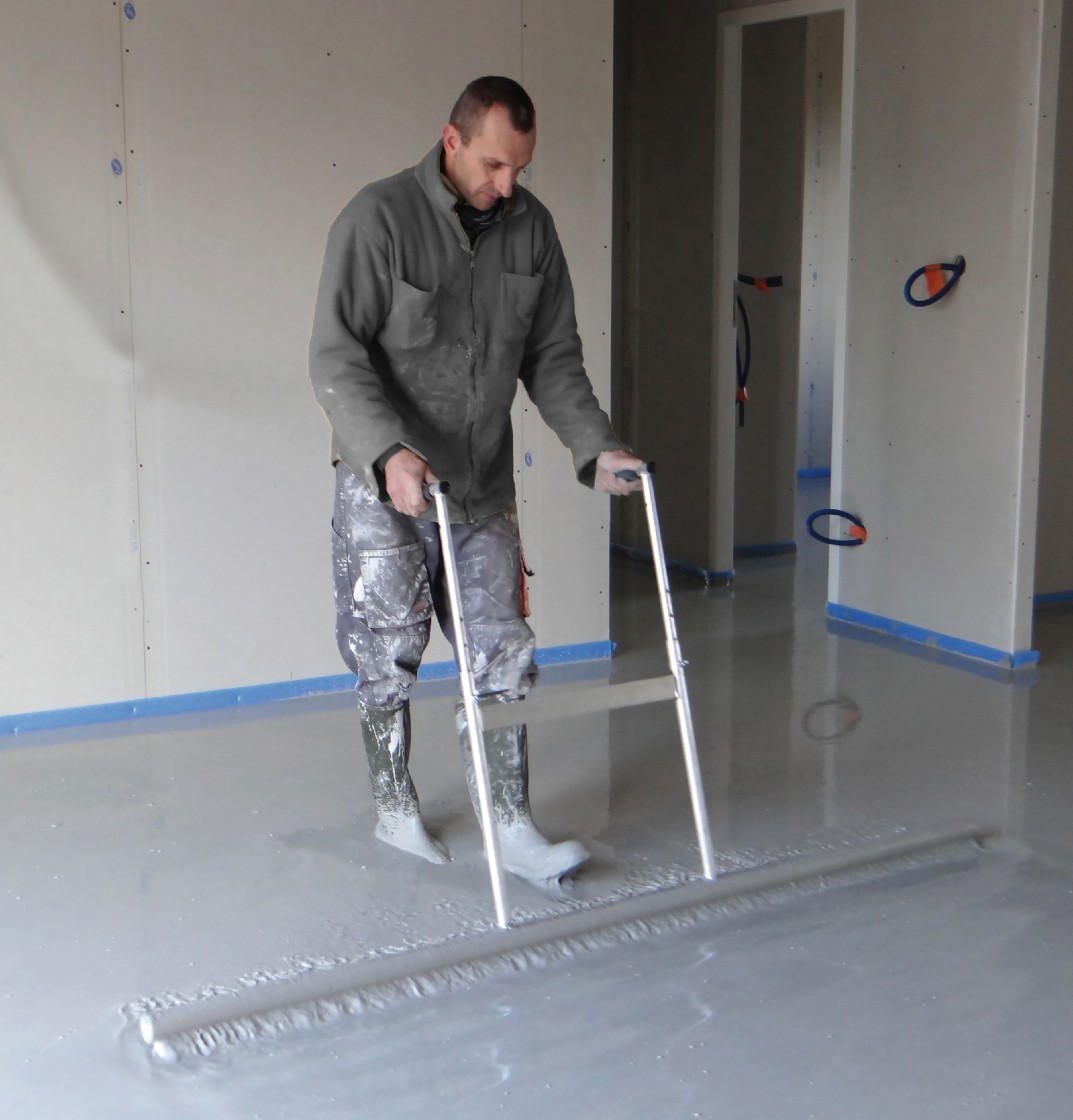 Artisan dallagiste utilisant la lisseuse de dalle béton professionnelle sur perche par Mondelin