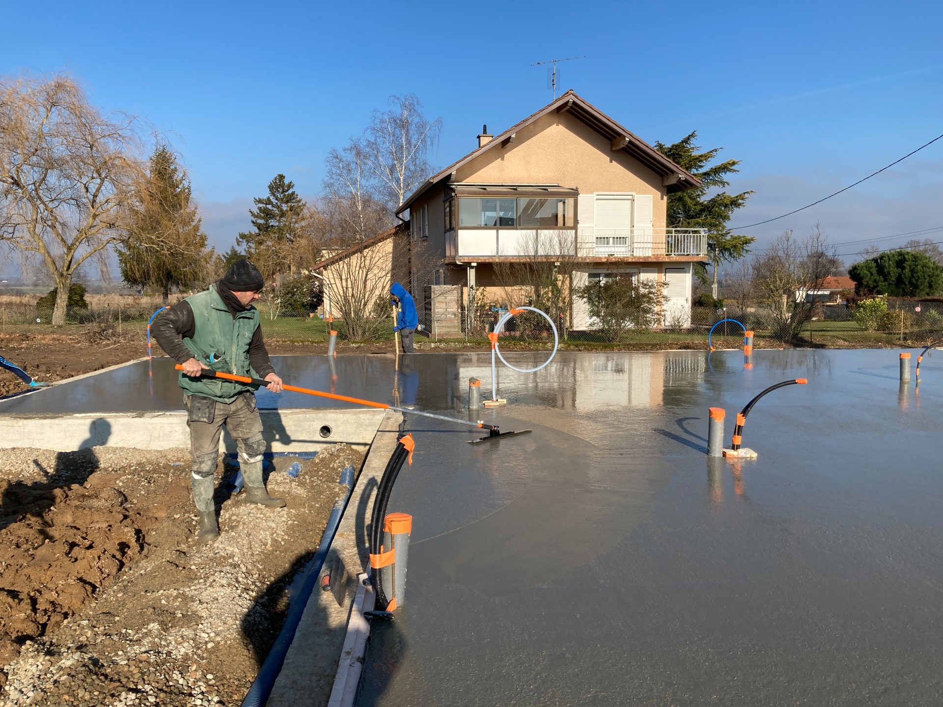 Artisan dallagiste utilisant la lisseuse de dalle béton professionnelle sur perche par Mondelin